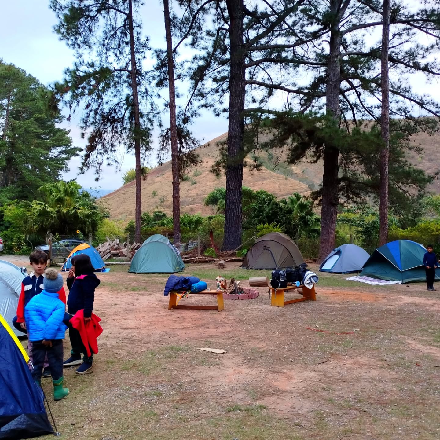 Acampamento da comunidade Casa Áurea entre árvores e montanhas
